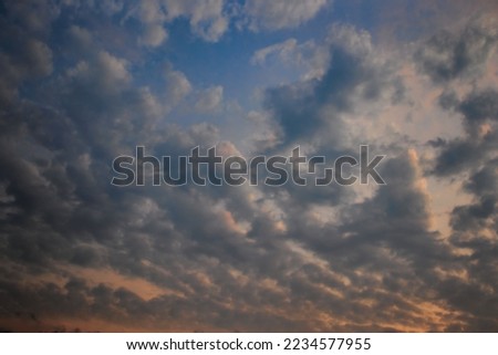 angelic twilight sky, in pastel tones, with white clouds floating under a capri blue sky, shaded with orange on the horizon line.