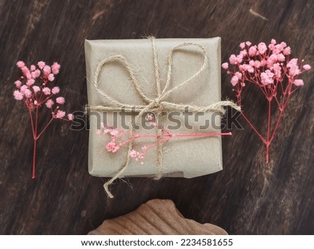 Brown gift box on old wooden table and decorated with flowers dried for birthday, Christmas or New Year.