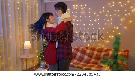 asian lovely young couple are dancing together happily with decorated christmas tree on xmas at home