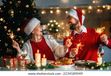 Merry Christmas. Happy loving couple is having dinner at home. Celebration holiday and togetherness near tree.