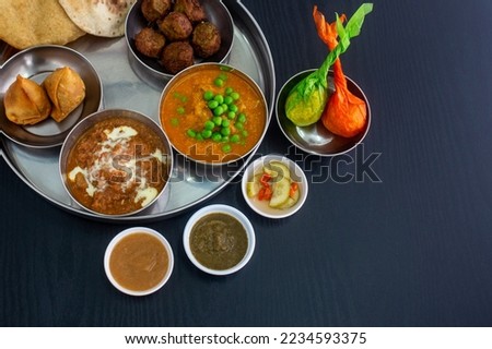 Indian Food Curry Butter Chicken, Palak Paneer, Chiken Tikka, Biryani, Vegetable Curry, Papad, Dal, Palak Sabji, Jira Alu, Rice with Saffron on Dark Background Royalty-Free Stock Photo #2234593375