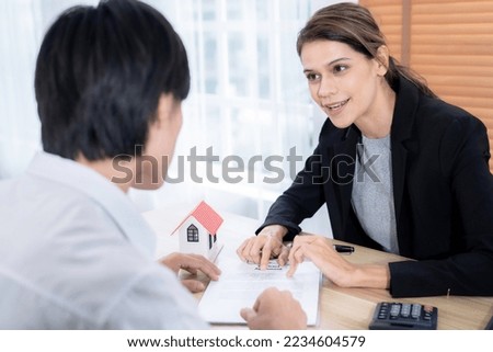The real estate agent talks to the client about the terms of the home purchase agreement and asks the client to sign the paperwork to complete the sale.