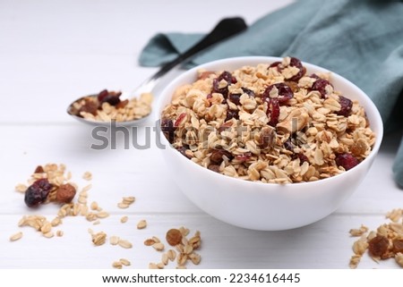 Bowl of tasty granola on white wooden table Royalty-Free Stock Photo #2234616445