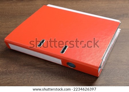 Orange hardcover office folder on wooden table, closeup