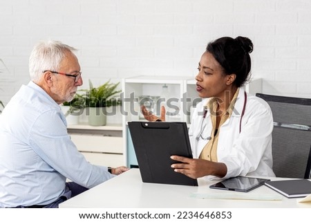 Depressed male senior adult in ambulance with afro american doctor. Doctor support and comforting her patient with sympathy Royalty-Free Stock Photo #2234646853