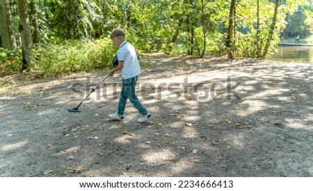 a boy with a metal detector in the forest is looking for treasure. High quality photo