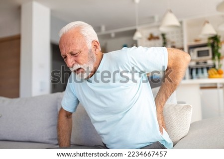 Senior elderly man touching his back, suffering from backpain, sciatica, sedentary lifestyle concept. Spine health problems. Healthcare, insurance Royalty-Free Stock Photo #2234667457