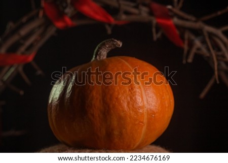 Yellow-orange pumpkins with crown of thorns on a black background the concept of Halloween and the autumn harvest of pumpkin close-up copyspace from above