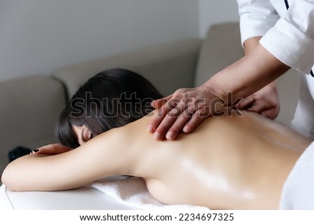 Pleasure of manipulation Ayurvedic massage therapist working on the back of a woman greased with scented and warm oil. Alternative ayurveda ayurvedic body business card closeup concept conscio