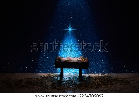 Nativity of Jesus, empty manger at night with bright lights.