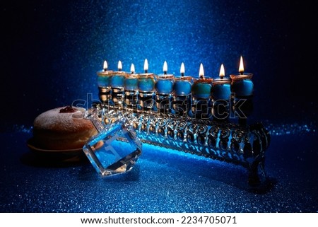 Jewish holiday Hanukkah background with menorah and dreidel with letters Gimel and Nun. Royalty-Free Stock Photo #2234705071