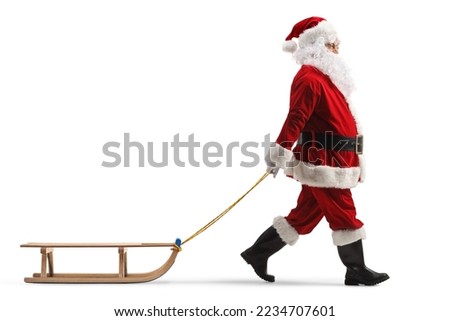 Full length profile shot of santa claus pulling a wooden sleigh isolated on white background Royalty-Free Stock Photo #2234707601