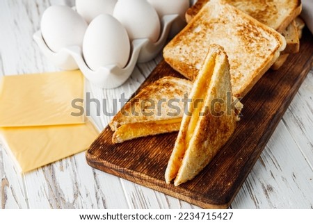 delicious cheese sandwich on a white rustic wooden background.
