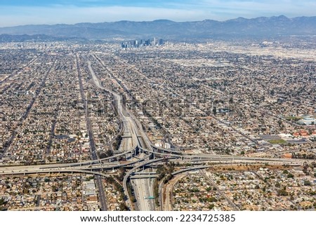 Aerial view of highway interchange Harbor and Century Freeway traffic with downtown city Los Angeles, USA Royalty-Free Stock Photo #2234725385