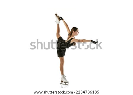 Young teen girl, junior female figure skater in black stage costume skating isolated over white background. Concept of skills, sport, beauty, winter sports. Copy space for ad