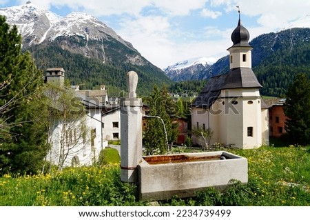Scenic Swiss countryside with its quaint old houses and an ancient church in Engiadina Bassa Region, Swiss canton Graubuenden in the snowy Swiss Alps Royalty-Free Stock Photo #2234739499