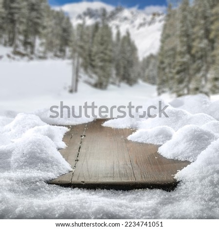 Wooden board of free space and winter landscape of mountains. Board cover of snow flakes and cold winter day. 