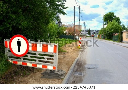 Barrier prohibiting entry , roadside where the footpath will be built