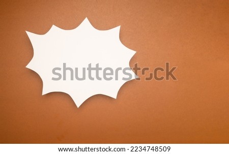 A blank white comic speech bubble on a brown background. Space for text. Top view