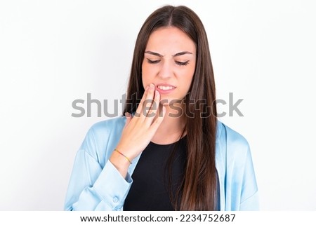 Young caucasian woman wearing blue overshirt over white background touching mouth with hand with painful expression because of toothache or dental illness on teeth.