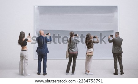 People at the art gallery, they are taking pictures of a painting using their smartphones