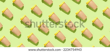 Many paper coffee cups on green background