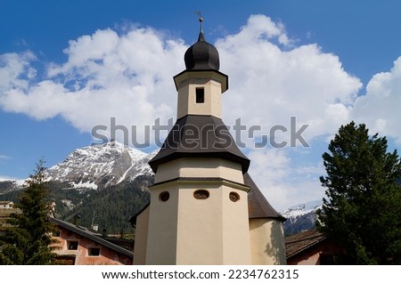 Scenic Swiss countryside with its quaint old houses and an ancient church in Engiadina Bassa Region, Swiss canton Graubuenden in the snowy Swiss Alps                                Royalty-Free Stock Photo #2234762315