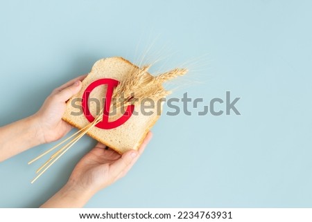 Hand holding a Bread slice marked with gluten free. celiac disease cover background  Royalty-Free Stock Photo #2234763931