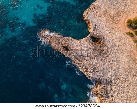 Aerial views with a 4k drone, in a centinal direction of rocks and sea where you can appreciate the colors, contrasts and textures that the Mediterranean seas of the Balearic coast, Europe.