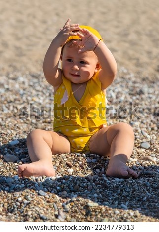 Baby is sitting on the beach by the sea. Selective focus. Sea.