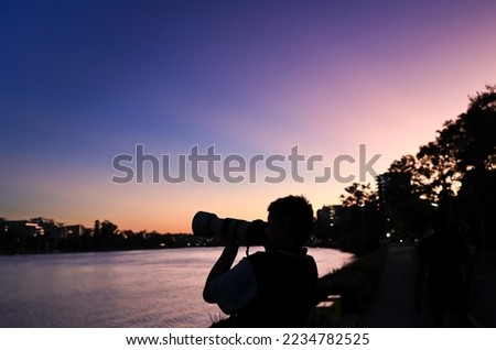 silhouette of a person taking pictures at sunset
