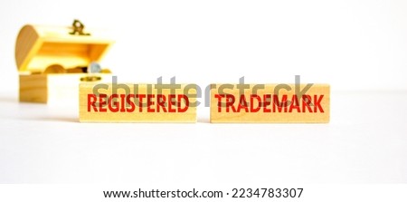 Registered trademark symbol. Concept word Registered trademark wooden blocks. Beautiful white table white background. Wooden chest with coins. Business and registered trademark concept. Copy space.