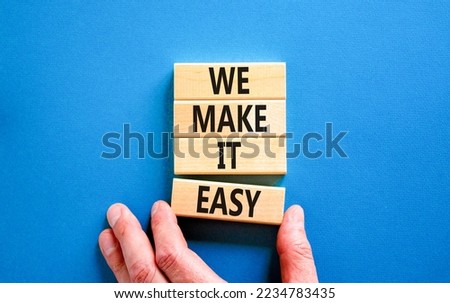 We make it easy symbol. Concept words We make it easy on wooden cubes. Beautiful blue table blue background. Businessman hand. Business motivational we make it easy concept. Copy space.