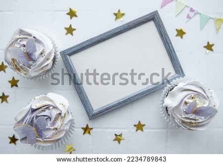 Birthday holiday cupcakes with butterfly decorations and picture frame - holiday background