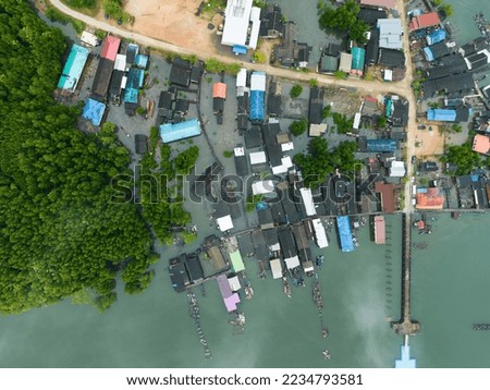 Aerial view top view of the fisherman village with fishing boats and house roof at the pier in Phangnga Thailand, Panorama high angle view
