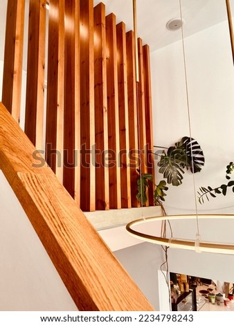Wooden deck wall design board in cafe, with flower pots and round tube lightning in the corner