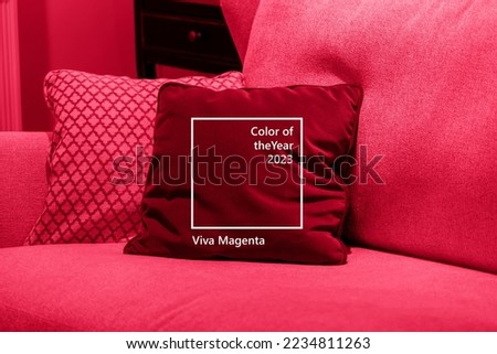 Image toned in color of year 2023 pantone Viva Magenta. cushions on cozy red sofa. Pillows on casual couch in the living room