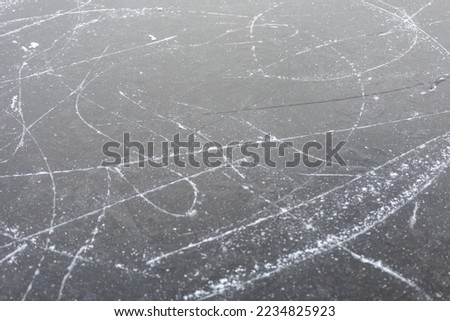 Frozen lake ice with ice skate tracks.