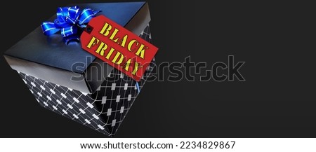 black gift box with blue and golden ribbon and tag written
"black friday" with inscription golden letters With blank space to write.
gift and sale concept