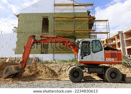 Excavator. construction equipment against the background of a new building