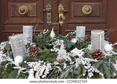 Christmas ornaments with advent candles in front of the church door
