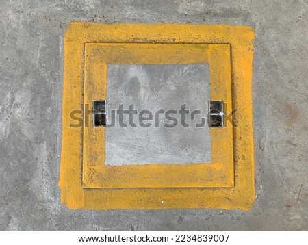 This is the concrete cover of the manhole painted as yellow color surrounding the corner.