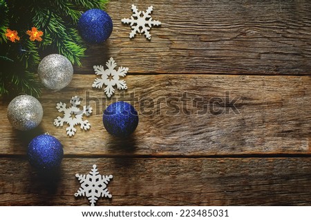 Christmas decorations with Christmas balls with fir tree branch and snowflakes on a dark wood background. tinting. selective focus on the right ball. 