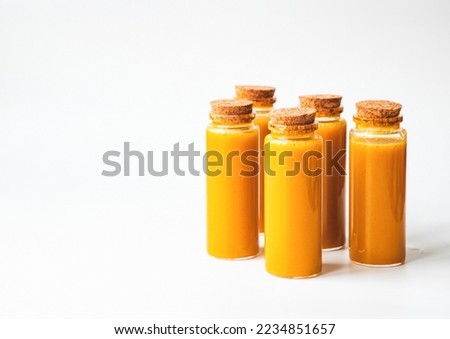 Homemade Immune Boosting Turmeric Ginger Citrus Shots. Anti-Inflammatory Vitamin Rich Healthy Drink. Flat-lay over white background, top view, free space for text