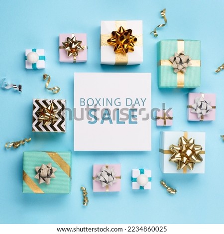 Boxing Day Sale promotion composition background. Christmas Shopping, Offer, Sale Concept. Holiday decorations and festive gift boxes on pastel blue background. Flat lay, top view, copy space.  Royalty-Free Stock Photo #2234860025