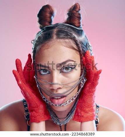 Stylish, goth and portrait of a woman with chains on her face on a pink studio background. Front, headshot and edgy fashion female with chain or metal accessories on her head with cool makeup