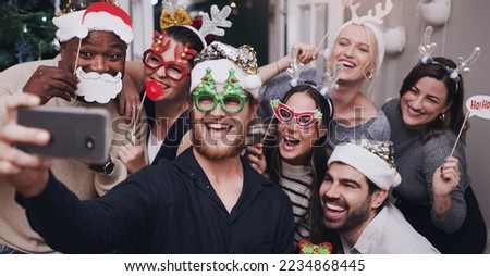 Christmas, party and friends taking a selfie on a phone together with goofy, funny and silly props. Diversity, festive and happy people taking picture on a smartphone at festive xmas event at a home.