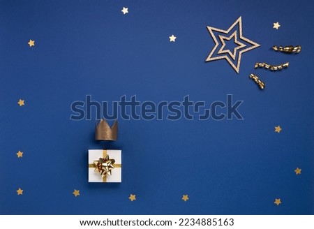Traditional Three King's Day of January 6. Gold crown and big star in winter night sky, blue background. Concept for Dia de Reyes Magos day, three Wise Men. Christmas Happy Epiphany day. Top view.