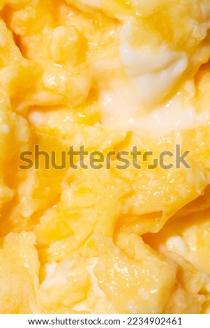 Texture of tasty scrambled eggs as background, closeup. Macro photo.