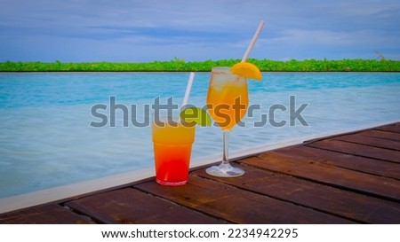 Close up of cocktails with a swimming pool. Two drinks is standing. Blue turquoise ocean on the background. Summer travel vacation concept.